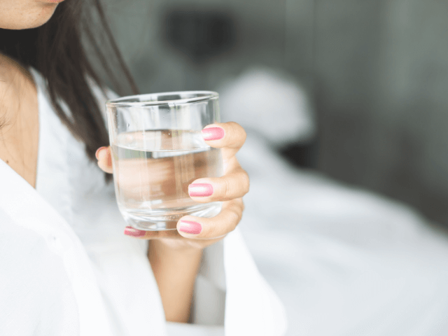 hydratation, femme tenant un verre d’eau